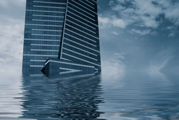 Commercial Flood Insurance - Abstract View of a Tall Building in Partly Submerged Water on a Gloomy Day